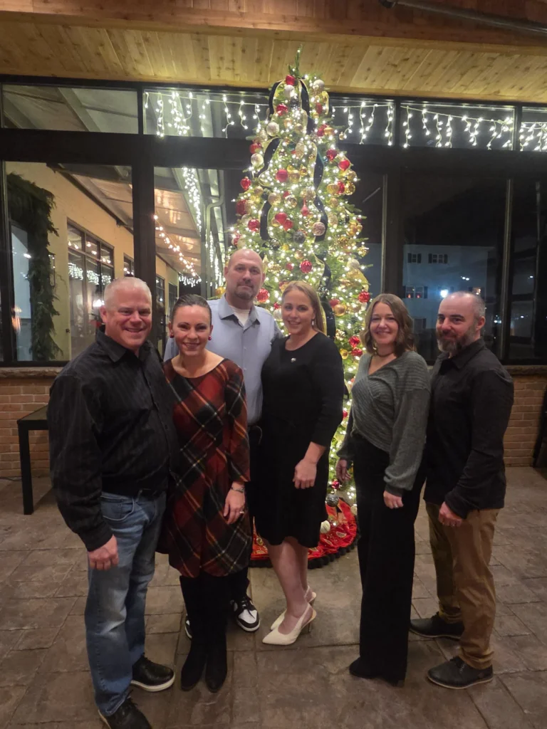 the team at Albanese Physical Therapy posing in front of a Christmas tree