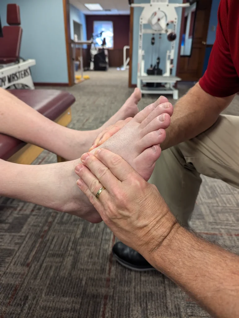 physical therapist examining patient's foot at Albanese Physical Therapy