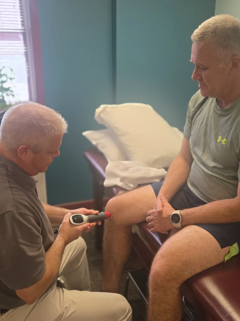 physical therapist using ultrasound therapy on a patient's knee at Albanese Physical Therapy